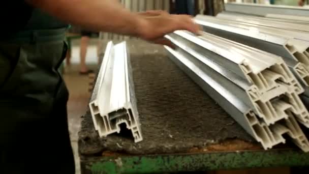 Producción de ventanas de pvc, trabajador masculino perfora los detalles de una ventana de perfil de pvc, primer plano, perfil de pvc — Vídeos de Stock