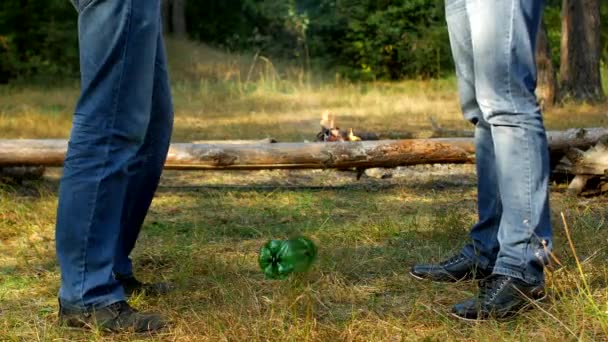 Två män prata i naturen, kasta ut en plastflaska och ledighet, camping, sopor och naturen, föroreningar — Stockvideo