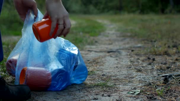 남자 청소부 신호 오렌지 조끼에 청소기 청소는 숲에 쓰레기 클로즈업 — 비디오