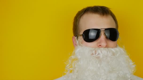 Retrato de homem com barba branca e óculos pretos, sobre fundo de parede amarelo — Vídeo de Stock