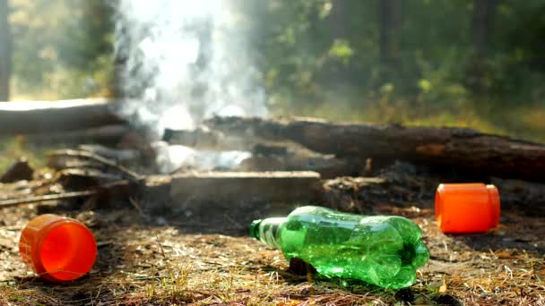 Rubbish left by people in a clearing in the woods, after outdoor recreation, fires are burning, pollution of nature is trash, litter, garbage — Stock Video