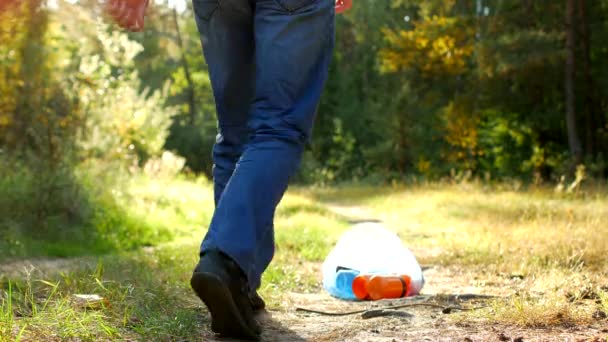 Manliga vaktmästaren renare i signal orange väst rengör sopor i skogen — Stockvideo