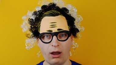 şaşırdım ve open-eyed kıvırcık adam, komik neşeyle insan duyguları üzerinde sarı duvar arka plan, siyah ve beyaz kıllar