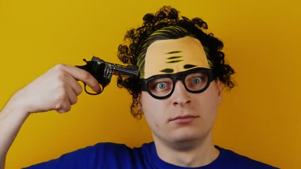 Homem encaracolado com pistola de brinquedo pistola atira na cabeça para se divertir — Vídeo de Stock