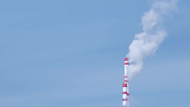 Временной дым из двух производственных труб загрязняет окружающую среду на фоне голубого неба, пара из труб производства — стоковое видео