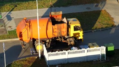 Bir çöp kamyonu çöp kutuları çöp konut alanından avlusunda temizler ve düzenli depolama için çöp kamyonu alır