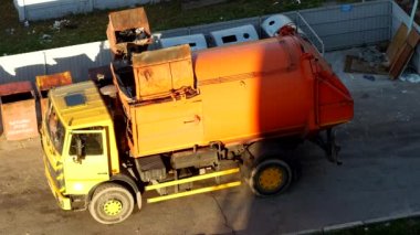 Bir çöp kamyonu çöp kutuları çöp konut alanından avlusunda temizler ve düzenli depolama için çöp kaldırma alır