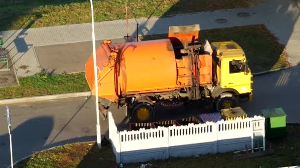 Un camion della spazzatura pulisce bidoni della spazzatura nel cortile di una zona residenziale dalla spazzatura e lo porta in discarica, rimozione della spazzatura — Video Stock