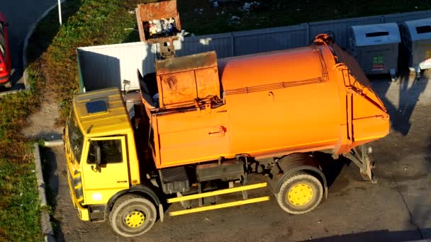 Un camion della spazzatura pulisce bidoni della spazzatura nel cortile di una zona residenziale dalla spazzatura e lo porta in discarica, cassonetto — Video Stock