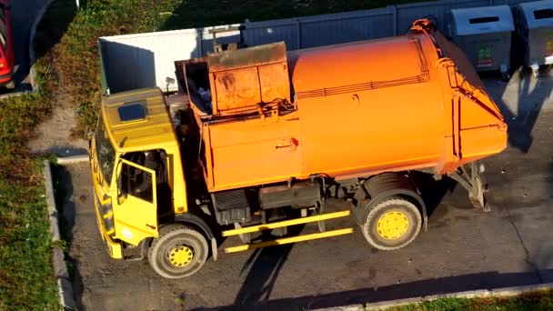 Un camion à ordures nettoie les poubelles dans la cour d'un quartier résidentiel des ordures et les emmène à la décharge, à la benne à ordures — Video