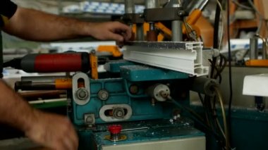 Üretim ve üretim pvc pencere, Erkek işçi üretimi pvc pencere, yakın çekim, makine-aracı matkap için bir matkap bir pvc profil üzerinde delik matkap