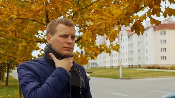 Ziek of ziek man houdt zijn keelpijn in stad of buiten in herfst of najaar, griep griepvirus — Stockvideo