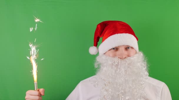 Homem como um Papai Noel com vela de fogos de artifício de mão ou sparkler, Natal e Ano Novo 2019, na chave Chroma verde, cinemagraph looped — Vídeo de Stock