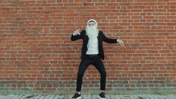 Человек, как Санта-Клаус танцует, Счастливого Рождества и Нового 2019 года, красная кирпичная стена в качестве фона — стоковое видео