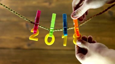 Sarı numaraları 2018 asılı bir ip üzerinde bir ahşap arka plan, yakın çekim, el üzerinde bir clothespin 2018 2019, ikame değiştirir