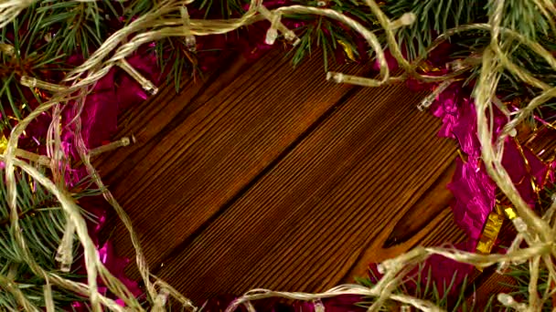 Christmas lights and spruce branches on a wooden background, the new year 2019, Christmas, a place for an inscription, decoration, copy space — Stock Video