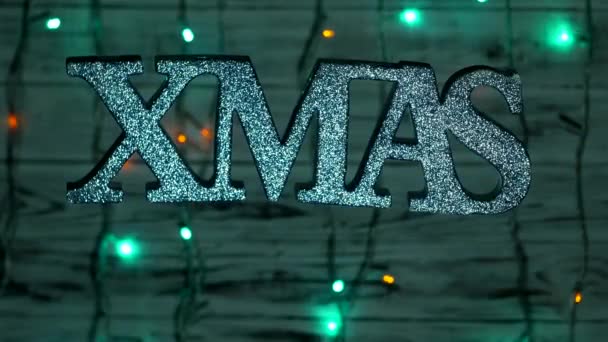 Inscription de Noël XMAS balancent librement dans les airs, sur un fond en bois, Nouvel An lumières, Nouvel An vacances, Nouvel An 2019, Noël — Video