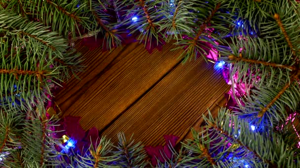 Julbelysning och spruce grenar på en trä bakgrund, det nya året 2019, jul, en plats för en inskription, dekoration, kopia utrymme, design — Stockvideo