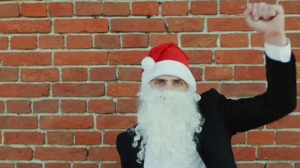 Homem como um Papai Noel está dançando, Feliz Natal e Ano Novo 2019, parede de tijolo vermelho como fundo — Vídeo de Stock