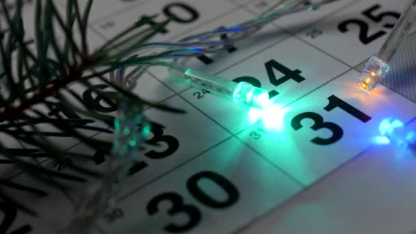 テーブルの上は新しい年 月カレンダーと クローズ アップ 新しい年 2019 年の日付の周りのライトが燃えている新年のカレンダー — ストック動画