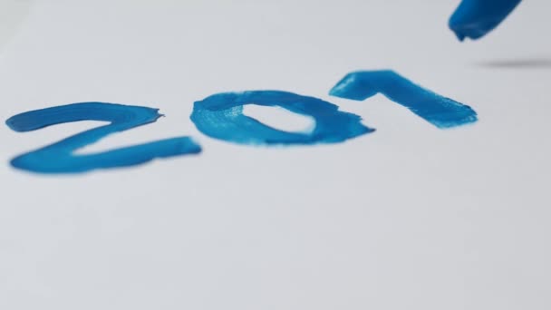 Een man tekent blauwe verf op een wit vel datum 2019, close-up, nieuwe jaar 2109, Kerstmis, winter — Stockvideo