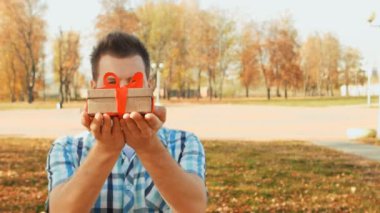 ciddi sakallı adam ellerini bir hediye kutusu ile dışarı tutar