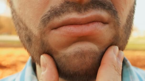 Hombre sin afeitar por su mano toca rastrojo de barba, de cerca — Vídeos de Stock