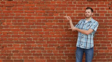 alan, tuğla duvar arka plan kopyalamak için tişört ve kot giyen şık sakallı adam