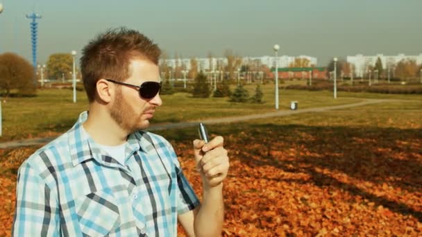 Стильний чоловік курить електронну сигарету вперше після кашлю — стокове відео