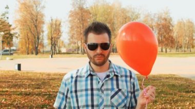 şık sakallı adam gözlüklü ve elinde kırmızı bir balon