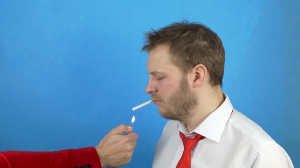 Beyaz bir gömlek ve kravat standları bir sigara ile sakallı bir adam, başka bir adam sigarasını için ateşe verir, onu itip duman, nikotin, Sigara için zarar kavramı — Stok video