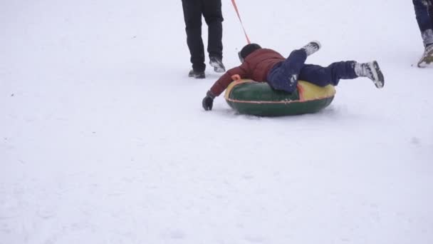 Padre enrolla a su hijo en la bañera en la nieve en invierno, lento mo — Vídeos de Stock