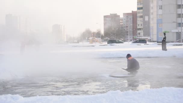 Mężczyzna robotnik wylewanie lodowisko na mroźny zimowy dzień, zwolnionym tempie — Wideo stockowe