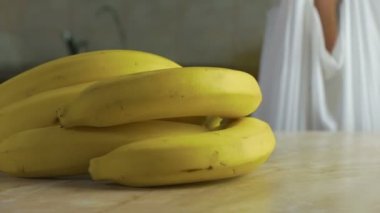 adam yavaş ev mutfak masasında olgun çiftlik meyveler koyar