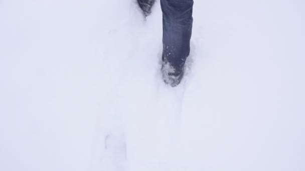 Man in de winter laarzen wandelen in diepe sneeuw in de winter, slow motion, weer — Stockvideo