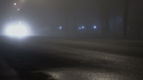 Camión de coche con faros encendidos que conducen en una carretera en la niebla por la noche, mala visibilidad debido a la niebla — Vídeo de stock