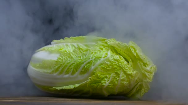 Napa chou est sur la table et de la fumée ou de la vapeur souffle par derrière dans slowmo, cloese up — Video