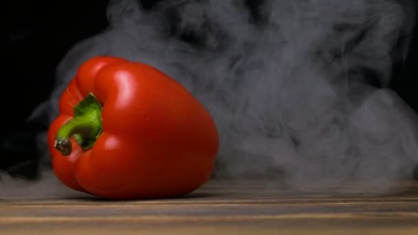 Granja de pimiento maduro o pimiento dulce está sobre la mesa y el humo sopla por detrás, cloese hasta 4K, espacio de copia — Vídeos de Stock