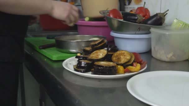 Gegrilltes Gemüse auf einem Teller im Hintergrund, der Koch schneidet Zwiebeln zum Marinieren und Braten auf dem Grill, Restaurant, Slow Food — Stockvideo