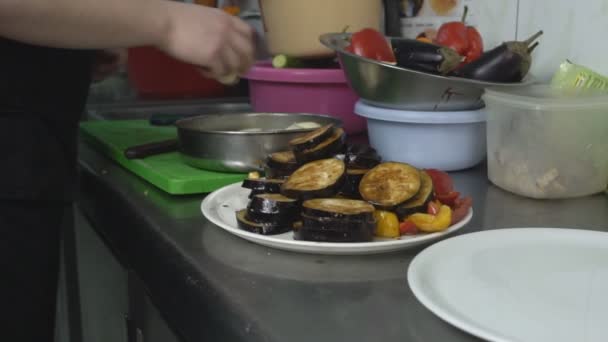 Ψητά λαχανικά σε ένα πιάτο στο παρασκήνιο, ο σεφ τεμάχια κρεμμύδια για μαρινάρισμα και ψήσιμο στο γκριλ, Εστιατόριο, αργή mo — Αρχείο Βίντεο