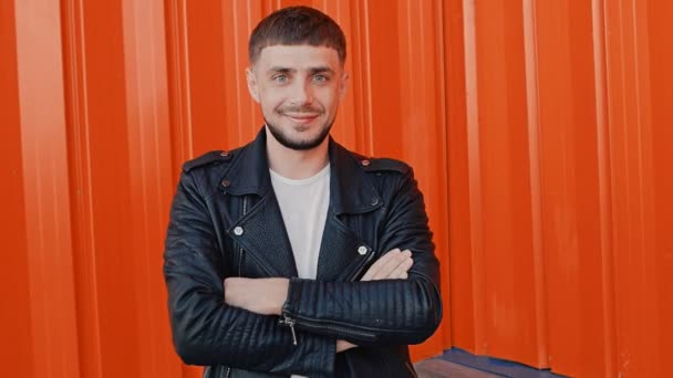 Retrato de hombre joven positivo de moda de pie cerca de fondo de pared naranja — Vídeos de Stock