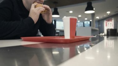 Aç yiyor bir lezzetli tavuk burger veya hamburger yavaş hareket