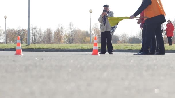 Babrujsk, Wit-Rusland - 21 oktober 2018: Karting competitie, de scheidsrechter zwaaien de vlag van de afwerking aan de afwerking, de concurrentie, de Slowmotion — Stockvideo