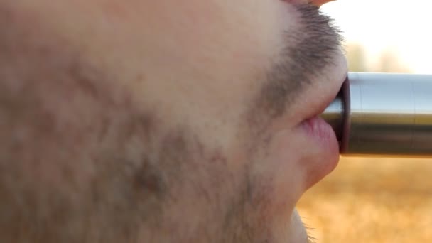 Бородатий білий чоловік курить вейп, крупним планом, зовні, повільно — стокове відео