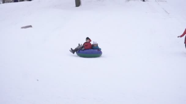 BOBRUISK, BELARO - 6 GENNAIO 2019: I bambini viaggiano ad alta velocità dalla montagna invernale in tubazioni, rallentatore — Video Stock