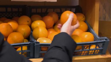 adam dokunur, hissediyor ve taze portakal Mağaza Pazar veya dükkan seçer