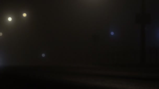 Coche con faros que conducen en una carretera brumosa por la noche, mala visibilidad debido a la niebla — Vídeos de Stock