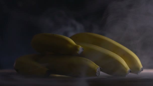 Bando de bananas Cavendish estão sobre a mesa a frio, vapor de geada em lentidão, cloese up — Vídeo de Stock