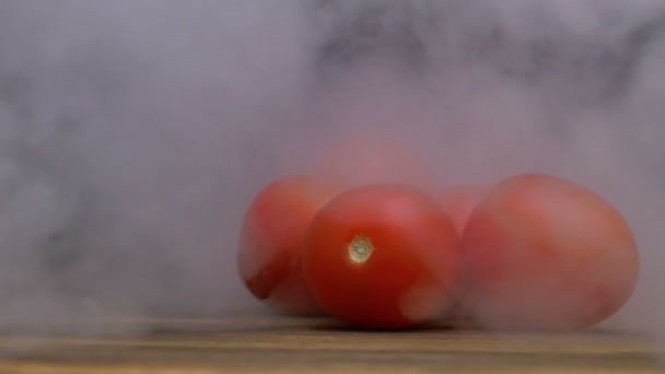 Tomates cereja frescos maduros estão sobre a mesa e fumaça sopra por trás, close-up 4K — Vídeo de Stock