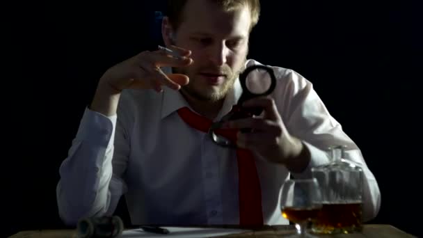 Muž, podnikatel s bradkou kouří a je nervózní, považuje pouta v rukou, na stole je alkohol, zatčení, úplatek — Stock video